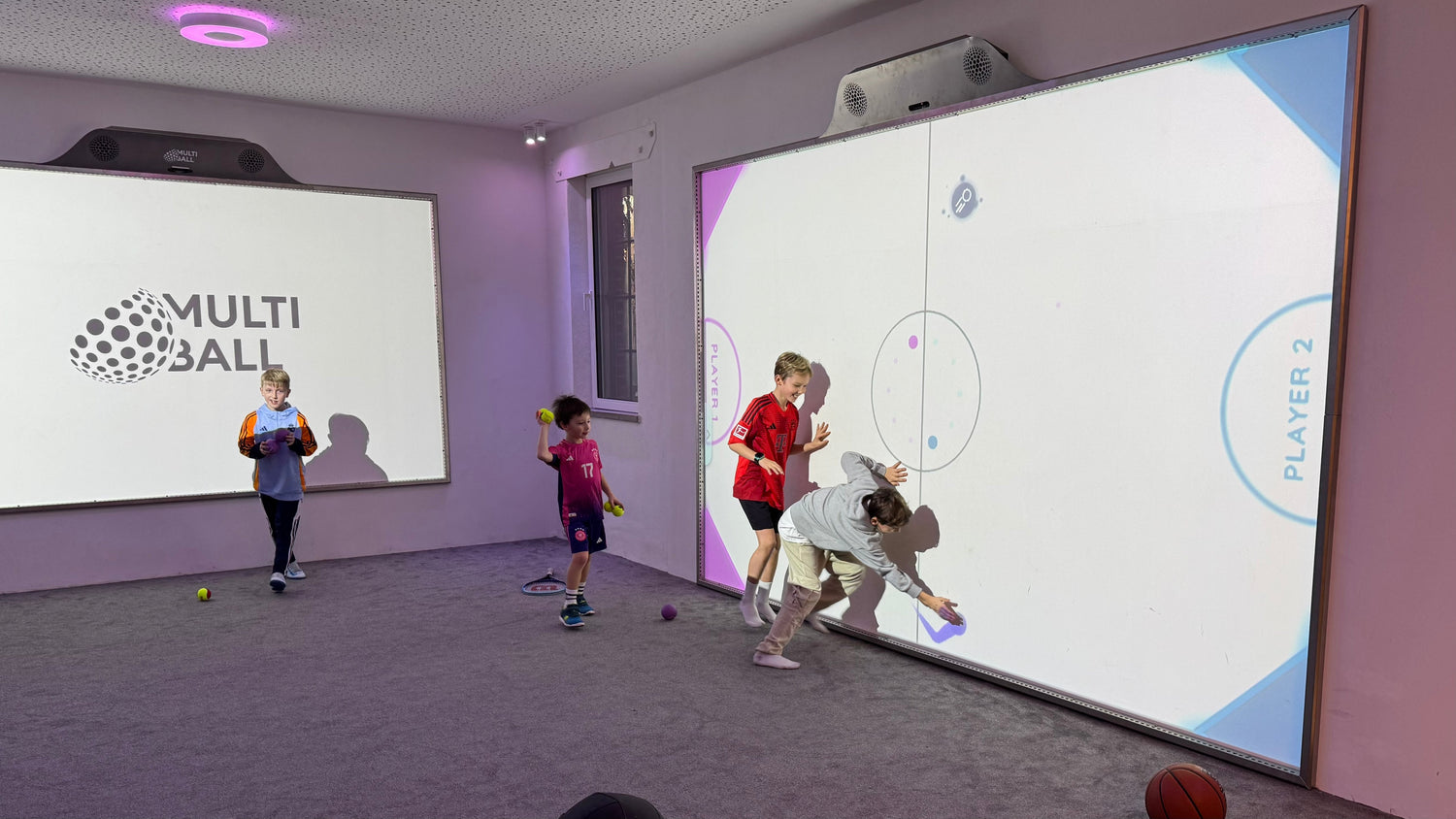 Kids standing in front of the MultiBall indoor system playing the Air Hockey Game