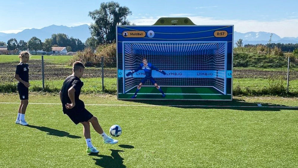 A young man playing soccer with an Interactive Sports Wall.