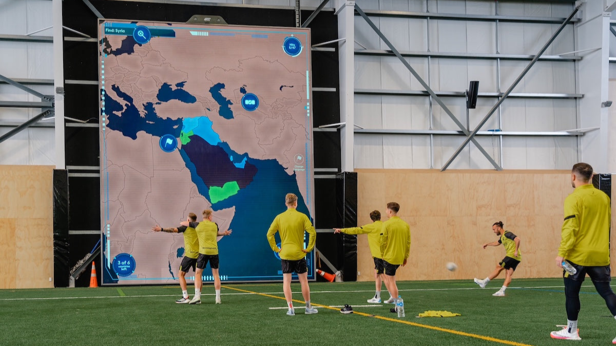 Players of a professional soccer club in Pheonix playing the game Countries on a very large MultiBall wall