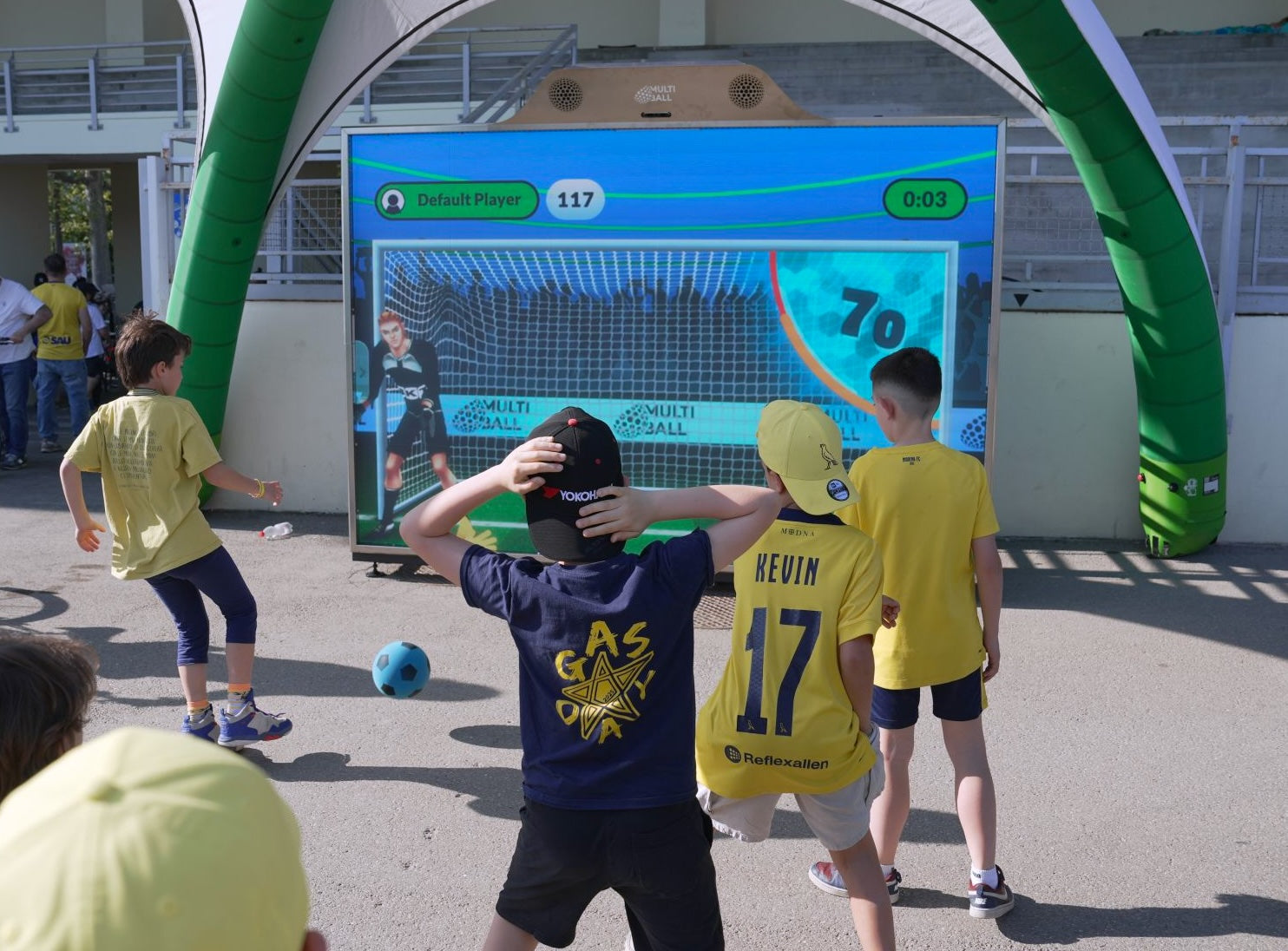 A boy kicking a soccer ball at the target in Goal 3D with many kids watching engage at a fan activation by Johannes Experiential Technology