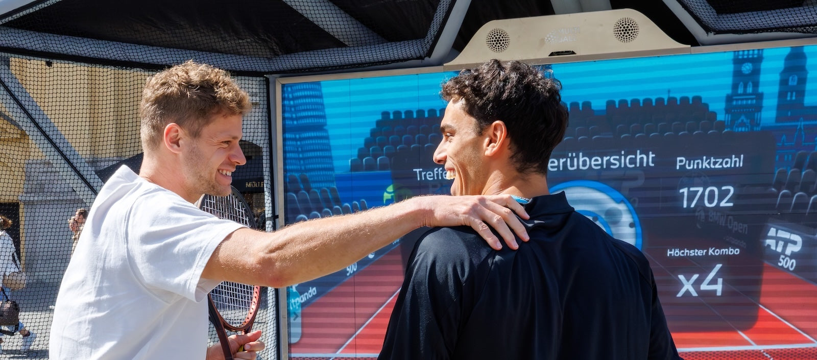 Close up of happy professional tennis players Yannick Hanfmann and Francisco Cerundolo celebrating after playing Tennis on the interactive sport wall MultiBall