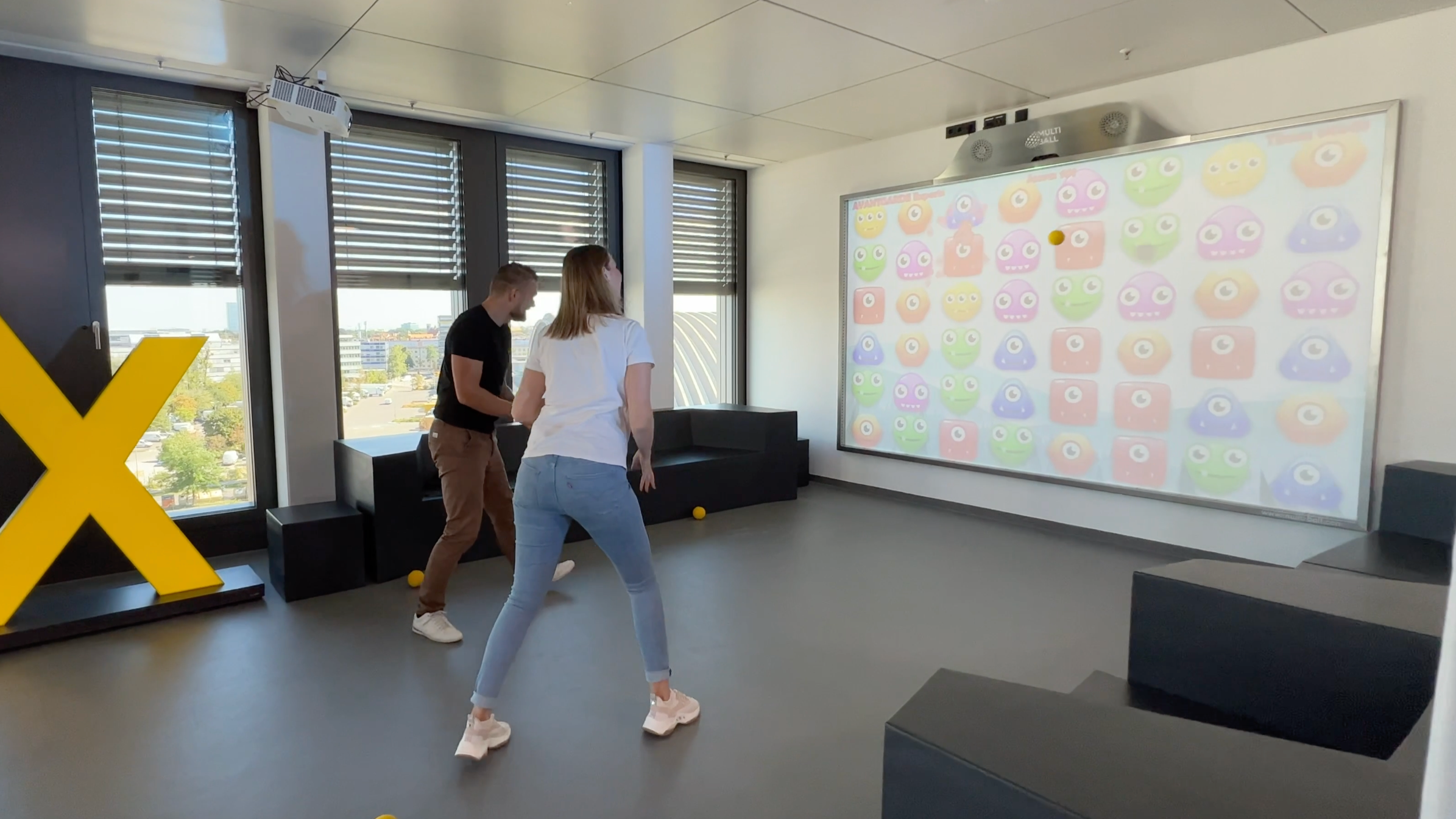 Two people playing the game Monster Match on the interactive wall MultiBall
