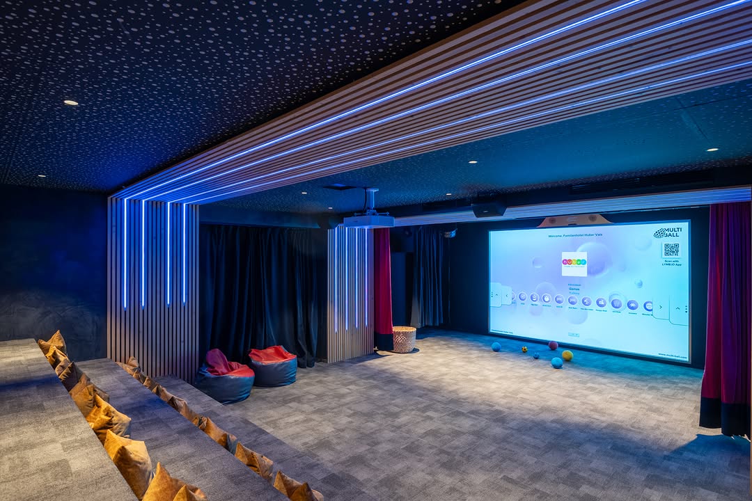 Theater and activity room with the interactive sports wall in the family hotel Huber in Vals. Used for playing games on MultiBall and for watching movies with the projector on the MultiBall.