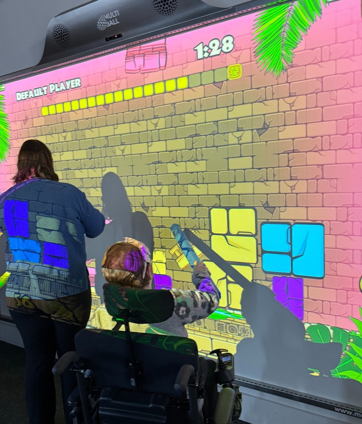 Two disabled people playing MultiBall in the SaskAbilities community center