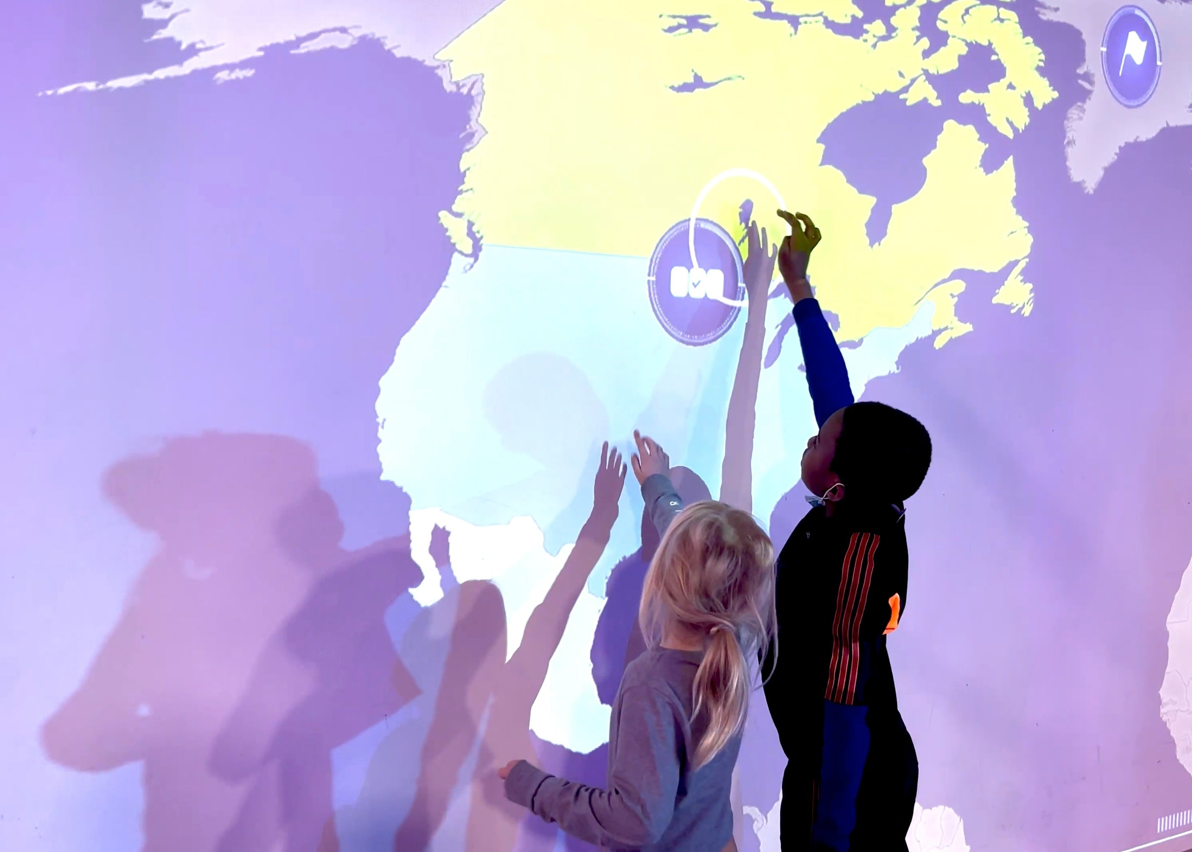 Two kids playing the education game countries on the interactive wall MultiBall