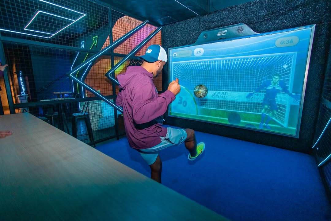 Person in a indoor cage playing soccer on the interactive sport wall MultiBall trying to hit targets in the Goal 3D