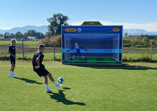 Young boy shooting a ball at the MultiBall LED System during a football training at DFI