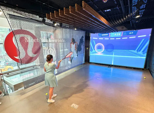 A girl participates in a virtual tennis challenge using MultiBall technology at Lululemon's 5th Avenue store, part of their US Open activation