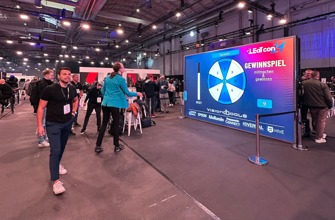 Trade show attendees interacting with MultiBall’s customizable system, showcasing a large display with a branded wheel game and personalized visuals.