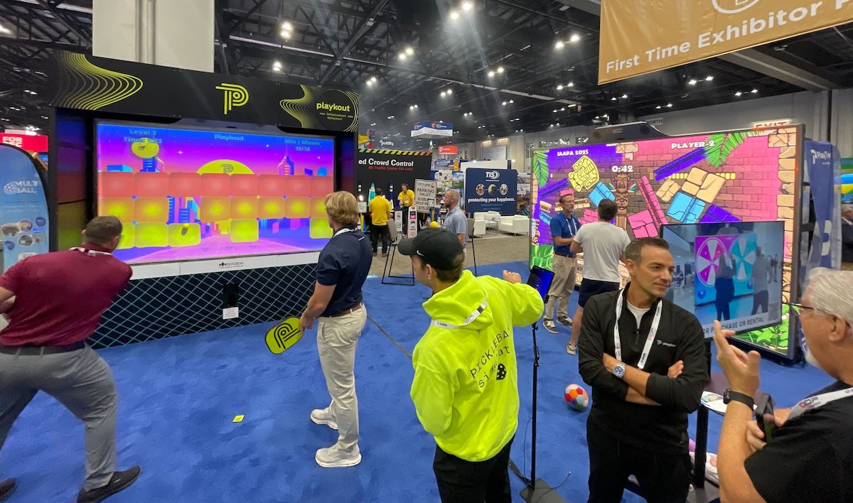 People playing on two MultiBall interactive walls at IAAPA 2025