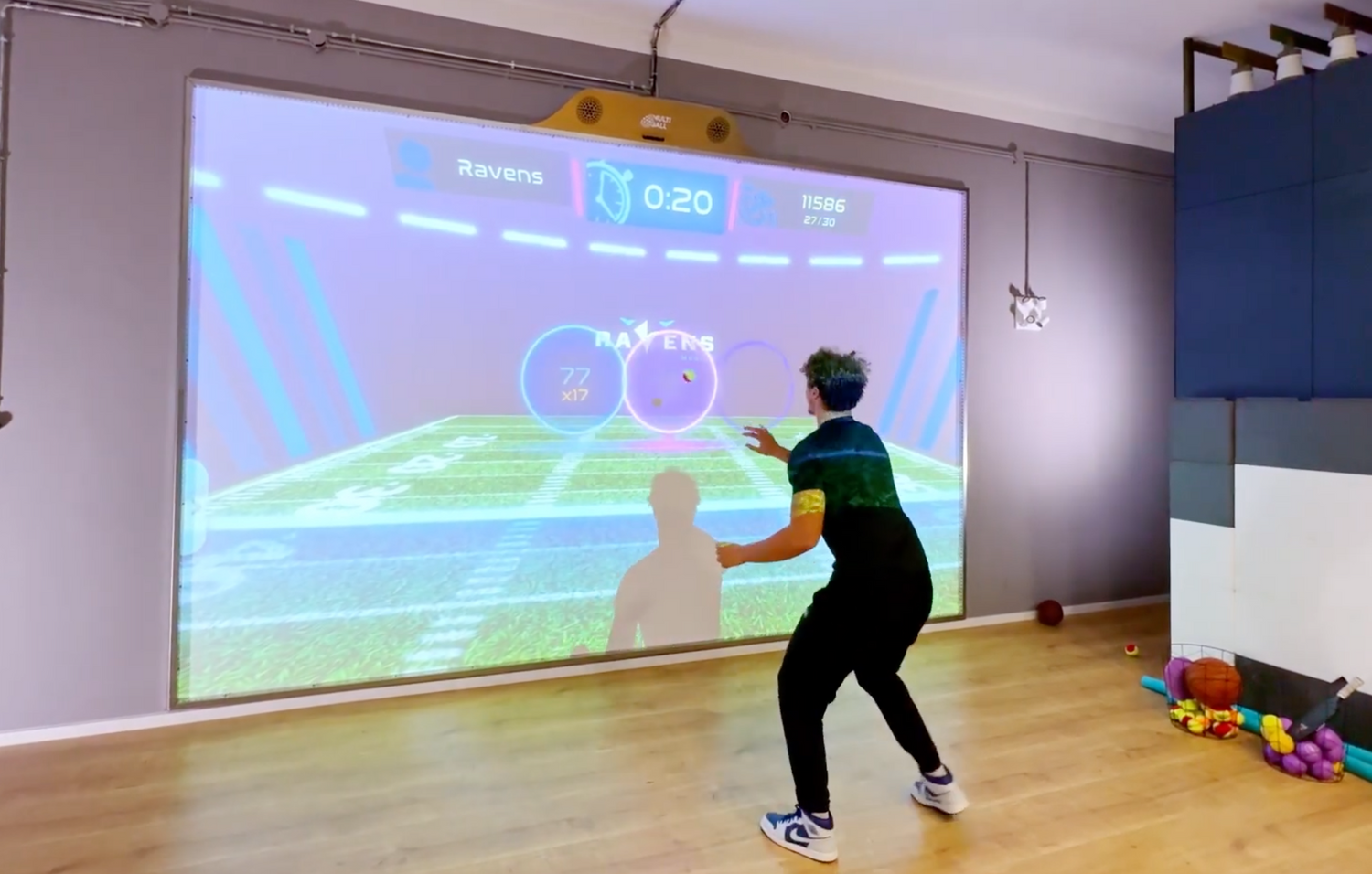 A professional american football player of the Munich ravens doing football training on the interactive sport wall MultiBall