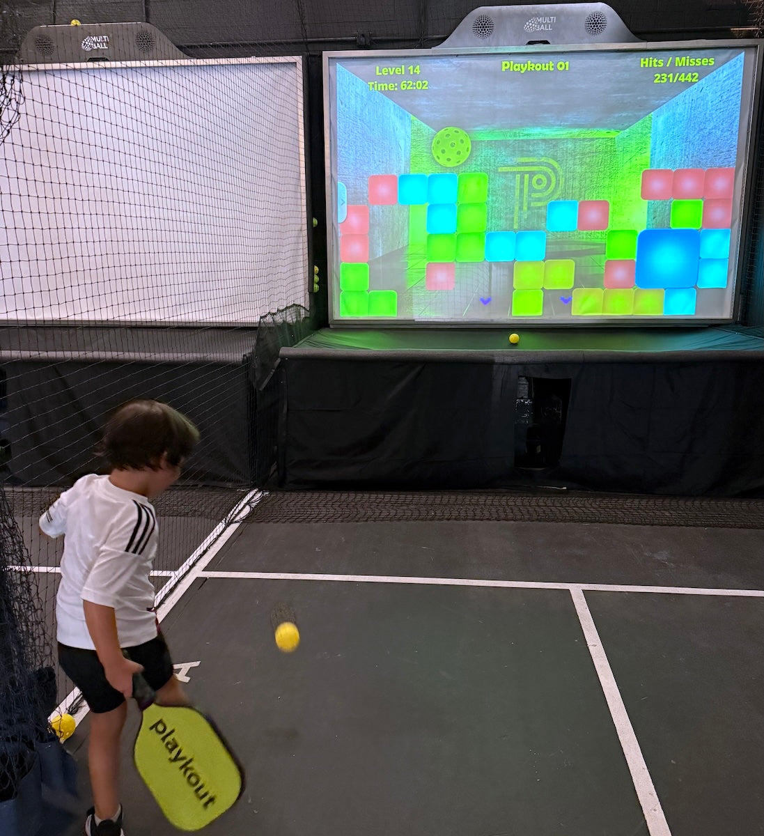 A young player practices pickleball with Playkout’s interactive MultiBall system, tracking hits, misses, and progress in a gamified, tech-enhanced environment.