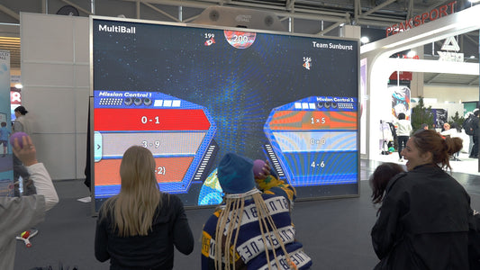 Group of people playing with a mathematics game on the MultiBall system and smiling