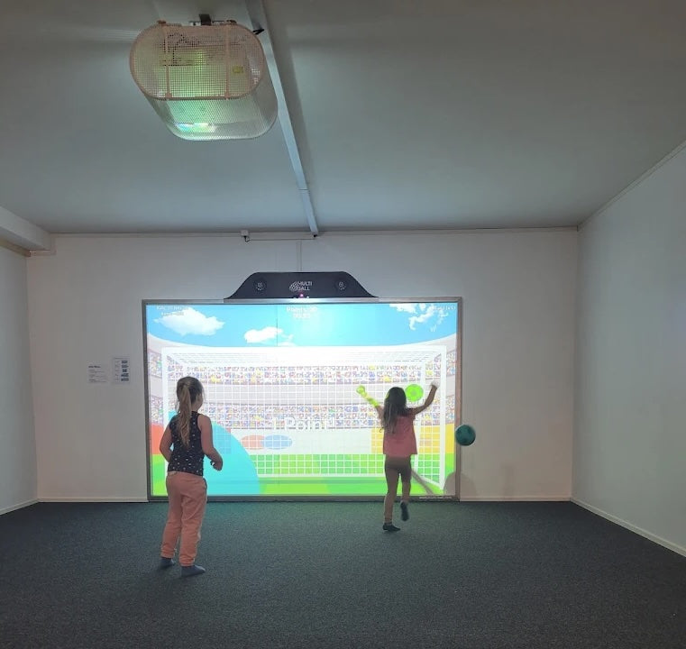 Kids playing soccer with joy on the interactive wall MultiBall in the indoor playground and trampoline park Fägnäscht