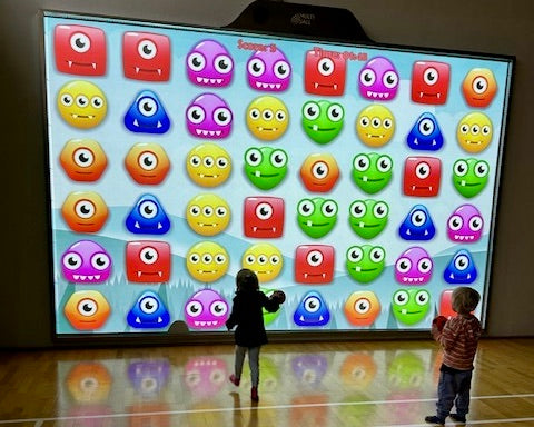 Two kids playing Monster Match at the MultiBall system