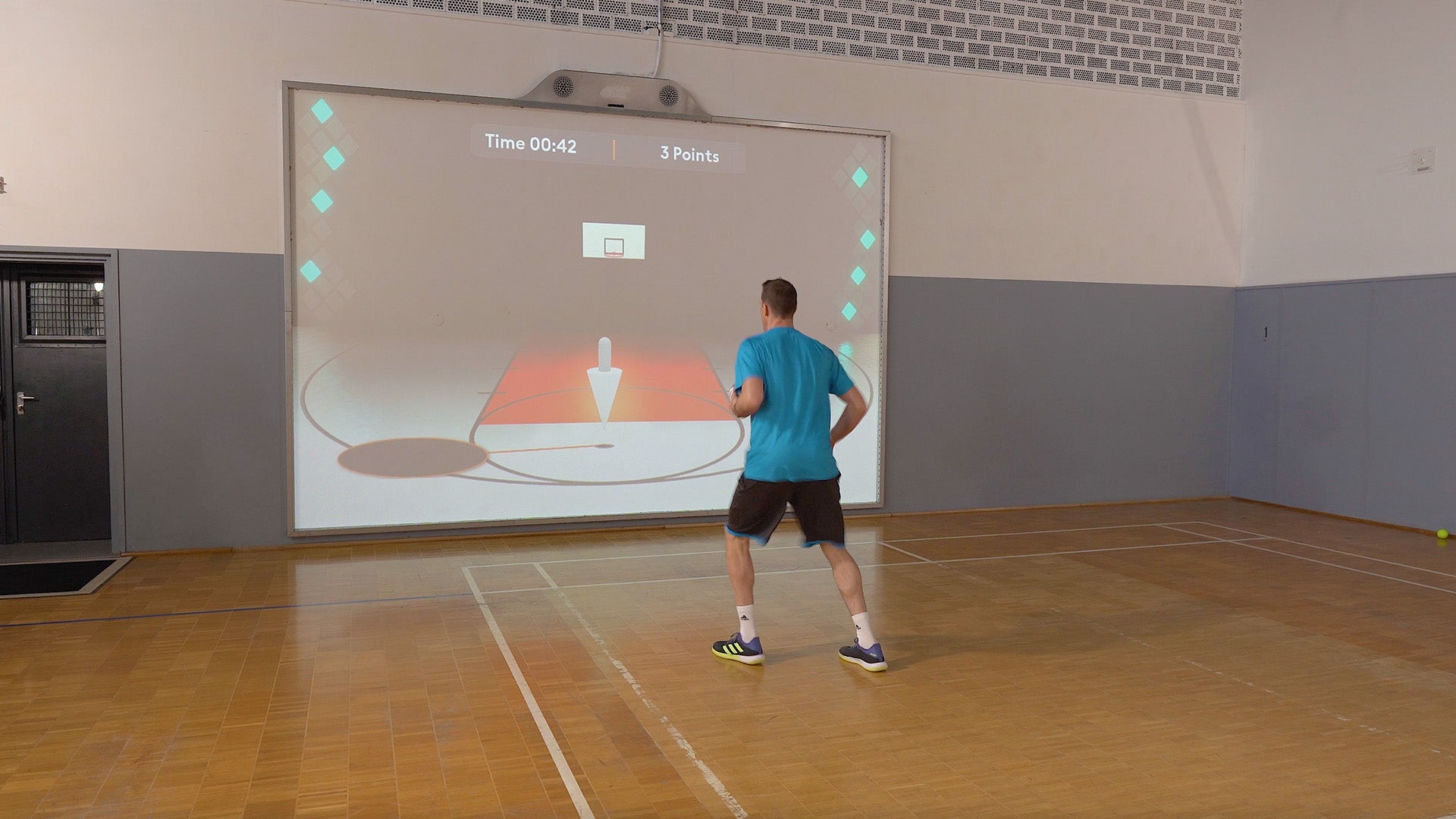 Dominik Klein playing the game Quick Feet  on an interactive MultiBall Pro projector system in a gym hall