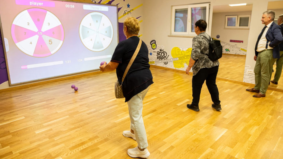 Two seniors playing the game Darts on the interactive sport wall MultiBall at the fitness center Sveti Petar u Šumi