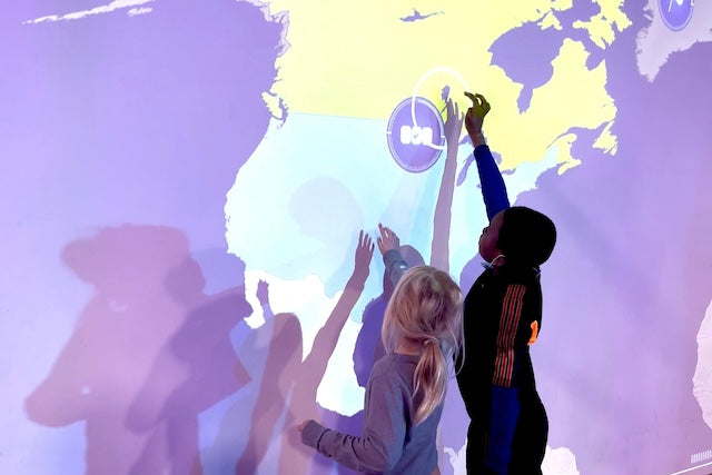 Two kids playing the education game countries on the interactive wall MultiBall