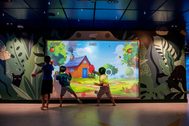 Kids playing the Balloon Mania game on MultiBall by throwing balls at the balloon in the play area of the cruise ship Aroya Cruises without any need for supervision