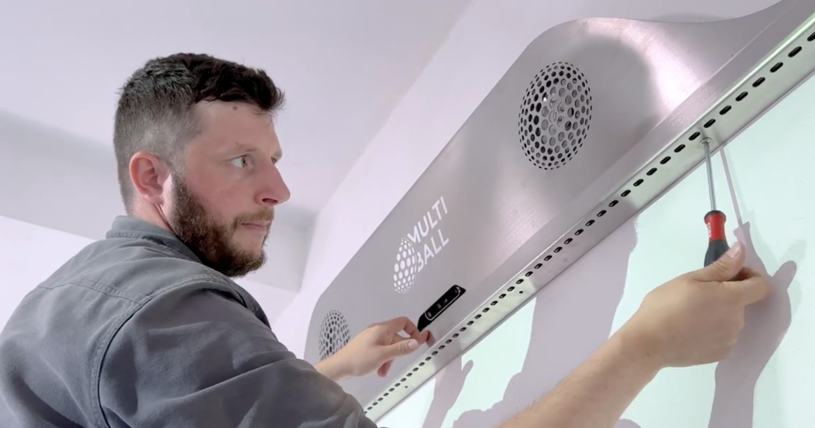 A person easily installing the MultiBall Console Cover with a screwdriver
