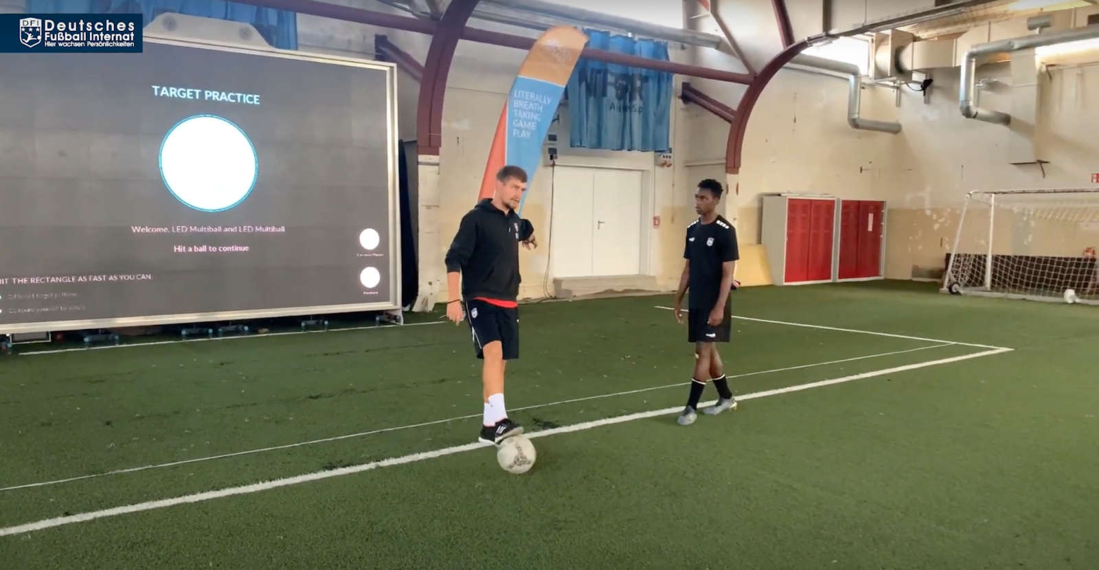 A coach explaining a soccer training drill at the DFI on the MultiBall wall