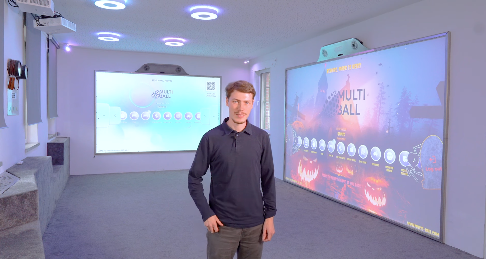 Mark standing in the MultiBall Playroom 1, in front of two interactive MultiBall walls