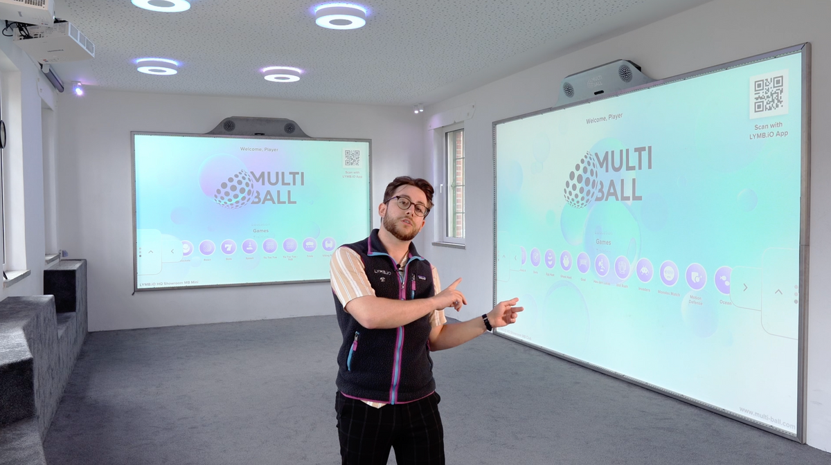 Head of Sales Joseph Kufner pointing at the MultiBall Club system for a online demo with a MultiBall Mini on the left side in the background.